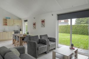 a living room with a couch and chairs and a table at Holiday Home Garden View in Tzummarum