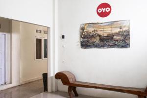 a painting hanging on a wall next to a bench at Hotel O Onong's Homestay Near Dodikjur Rindam XIII/Merdeka in Tomohon