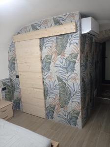 a bedroom with a wall with a mural of leaves at La casina al mare in Bari