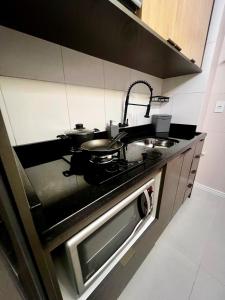a kitchen with a stove with pots and pans on it at ApComplete in the center in Caxias do Sul