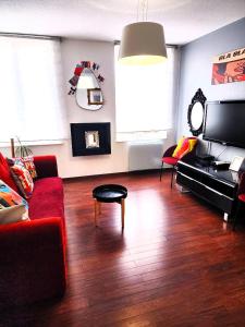 a living room with a red couch and a table at Appartement 3 pièces, Krutenau, Parking privé in Strasbourg