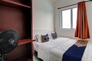 a bedroom with a bed and a fan and a window at Hotel O Anugrah Jaya Syariah Near Sekolah Dasar Negeri 018 Desa Kubang Jaya in Parit