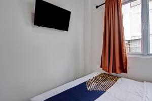 a bedroom with a bed and a television on the wall at Hotel O Anugrah Jaya Syariah Near Sekolah Dasar Negeri 018 Desa Kubang Jaya in Parit +18 photos