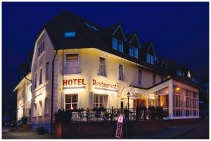 a hotel with a sign in front of it at night at Hotel Zur Linde in Schermbeck