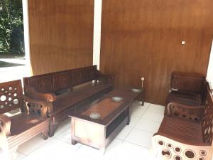 Tres bancos de madera situados encima de un porche. en Capital O 92612 Penginapan D'alas Purwo & BeachNearPadang Savana Sadengan, en Banyuwangi