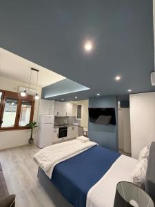a bedroom with a large bed and a kitchen at N&M Apartment in Chios