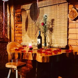 a table with a bottle of wine and a candle at Cabaña en la Calera Ciprés in La Calera