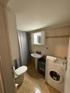 a bathroom with a toilet sink and a washing machine at N&M Apartment in Chios