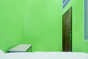 Cette chambre est dotée d'un mur vert et d'une porte. dans l'établissement Hotel O Joyoakis 2 Homestay SyariahNearMall Nagoya Hill, à Nagoya