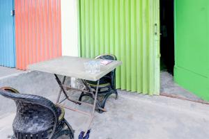 une table et deux chaises devant un bâtiment dans l'établissement Hotel O Joyoakis 2 Homestay SyariahNearMall Nagoya Hill, à Nagoya 18 autres photos