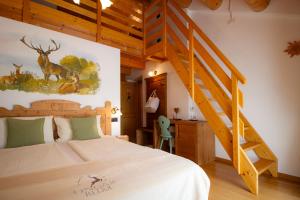 a bedroom with a bed and a wooden staircase at Ongar Relax b&b in Bosco Chiesanuova