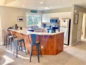 a kitchen with a bar with chairs and a refrigerator at FV16 Fairway Village Condo in Carroll