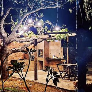 a wooden deck with a table and a tree at sitiolosbragas in Caetanópolis