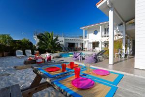a patio with a table with pink plates on it at Côte et Dune in Biscarrosse-Plage