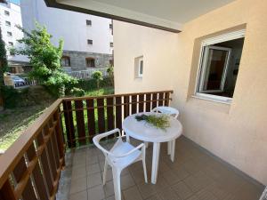 a small white table and two chairs on a balcony at My 3 stars BEE HAPPY studio in Brides-les-Bains +10 photos