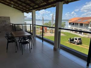a balcony with a table and chairs and a view of a yard at Apartmento - Lago das Roseiras in Divinópolis