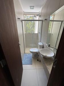 a bathroom with a toilet and a sink and a shower at Apartmento - Lago das Roseiras in Divinópolis