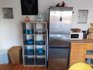 a kitchen with a refrigerator and a shelf with dishes at Glückstreffer in Meppen