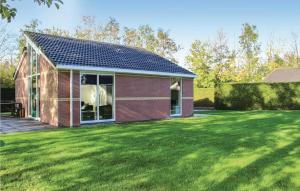 a red brick house with a large green yard at Holiday Home Garden View in Tzummarum
