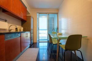 a kitchen with a table and chairs and a window at Charlotte's Place in Ponta Delgada