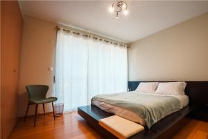 a bedroom with a bed and a chair and a window at Charlotte's Place in Ponta Delgada +34 photos