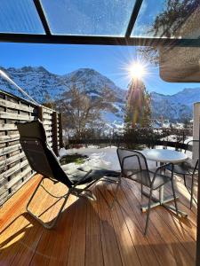 a patio with a table and chairs on a deck at Adelhome Studio mit Gartensitzplatz in Adelboden