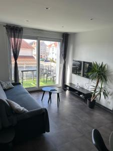 a living room with a couch and a large window at Le Channel in Camiers