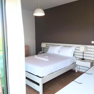 a bedroom with a bed with a white bed frame at ΣΥΜΗ View House in Mitikas +8 photos