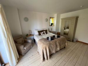 una camera da letto con un letto e una sedia di Stable Cottage by Roslin Glen a Roslin