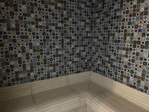 La salle de bains est pourvue d'une douche et d'un mur en mosaïque. dans l'établissement Dependence - Monte Argentario, à Isola Rossa 13 autres photos