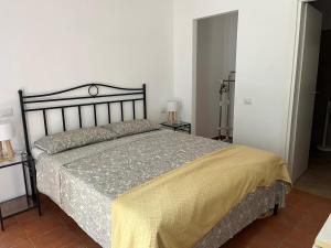 une chambre avec un grand lit avec une couverture jaune dans l'établissement Dependence - Monte Argentario, à Isola Rossa