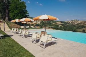 a group of chairs and umbrellas next to a pool at Agriturismo Camponovo in Brisighella