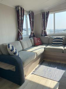 a living room with a couch and windows at Bude Holiday Resort Peace And Quiet in Bude +16 photos