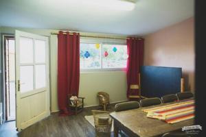 a room with red curtains and a table and a window at Domaine de la Ruade in La Chapelle-Saint-Sauveur