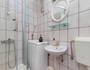 Un baño con inodoro, lavabo y espejo. en Old Town & Free Parking - Sweet Studio Apartment Dado with Balcony, en Split