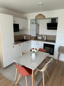 a kitchen with a white table and chairs at Casa Alma in Camiers +10 photos