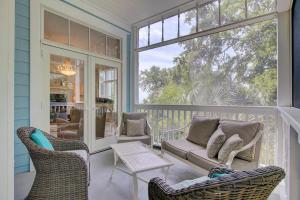 a porch with chairs and a couch and a table at 5 on 56th by Wild Dunes in Isle of Palms +69 photos