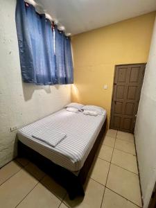 a small bed in a room with a window at Casa Colonial in León