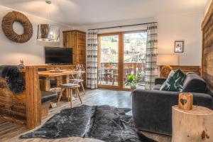 a living room with a couch and a desk with a television at Alpine Mountain Chalet in San Vigilio Di Marebbe