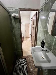 a bathroom with a sink and a mirror and a hallway at Casa Colonial in León