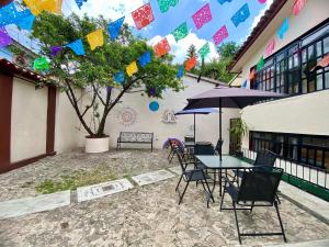un patio con una mesa con sillas y una sombrilla en El Balcón del Aventurero, en San Cristóbal de Las Casas