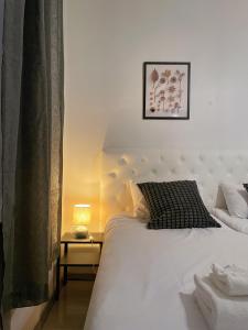 a bedroom with a large white bed and a lamp at Nextdoor Host Eco-lodge 24h Self Check-in with Bathtub in Helsinki