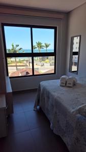 a bedroom with a bed and a large window at Ap Vista Mar 16 Minutos Beto Carrero Home Office in Piçarras