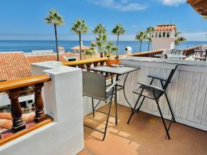 a balcony with a table and a view of the ocean at Bright Avalon Villa W Ocean Views & Hot Tub in Avalon