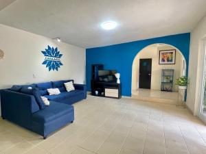a living room with a blue couch and a tv at Habitación #2 en Casa Azul in Tasquillo