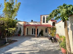 a house with a palm tree in front of a driveway at Habitación #2 en Casa Azul in Tasquillo