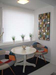 a room with a table and chairs and a window at The Kiss Apartment in Timişoara
