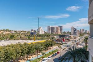 a city view of a street with palm trees and buildings at Calpe Vacaciones in Calpe