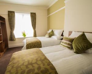 Habitación de hotel con 2 camas y ventana en Bloomfield Brewhouse, en Blackpool