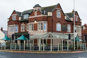 a large brick building with umbrellas in front of it at Bloomfield Brewhouse in Blackpool